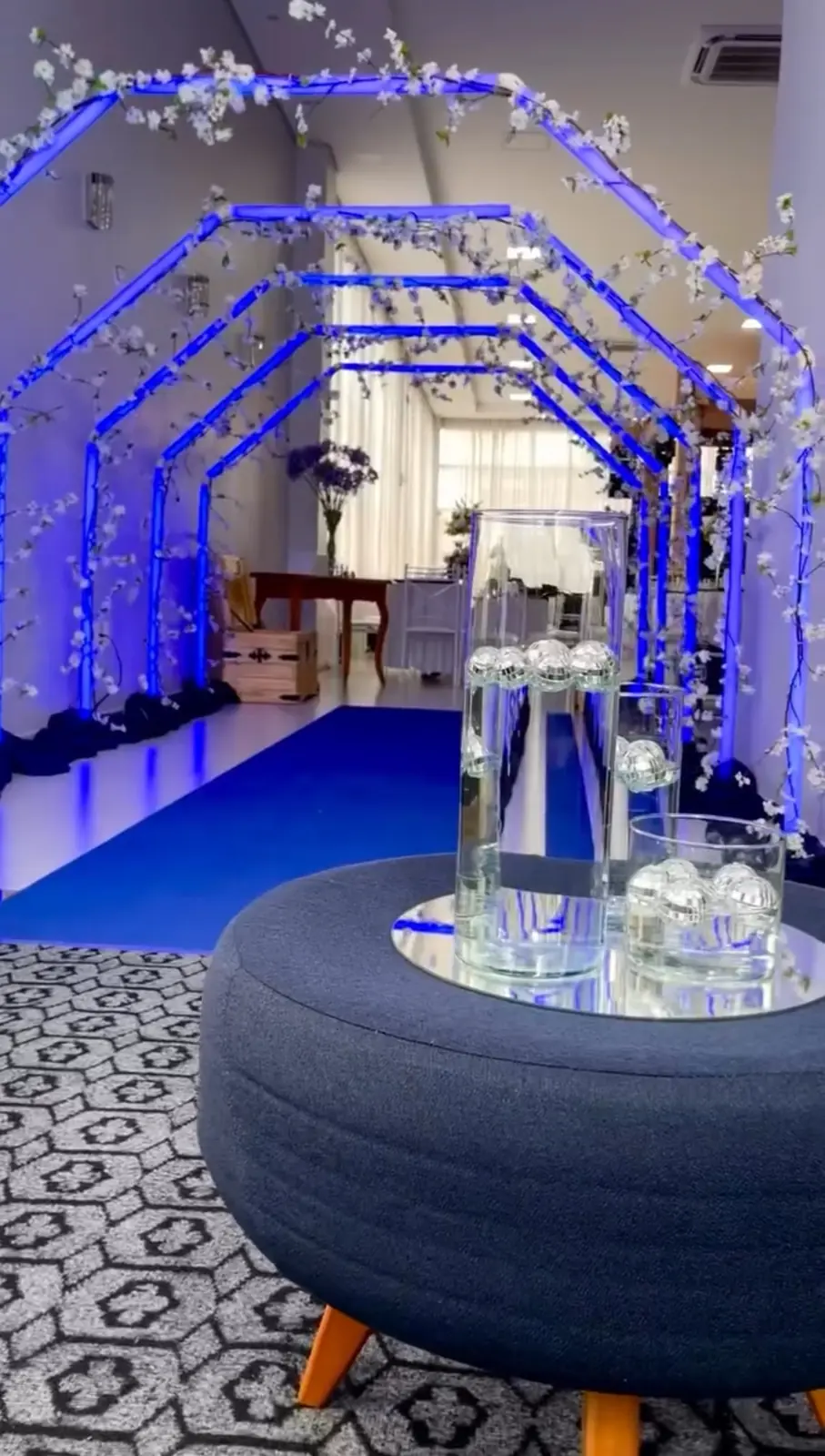 Túnel de entrada com arcos de LED azul e flores de cerejeira