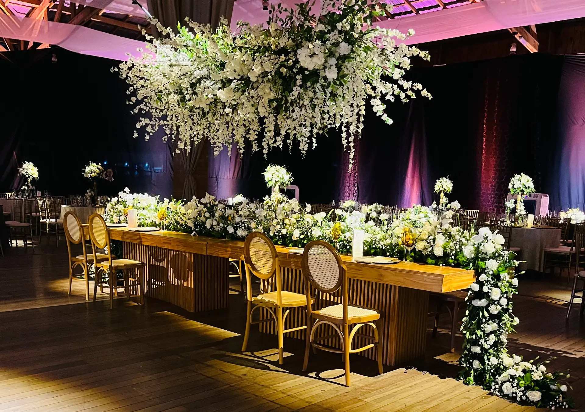 Mesa dos noivos com arranjo suspenso de flores brancas