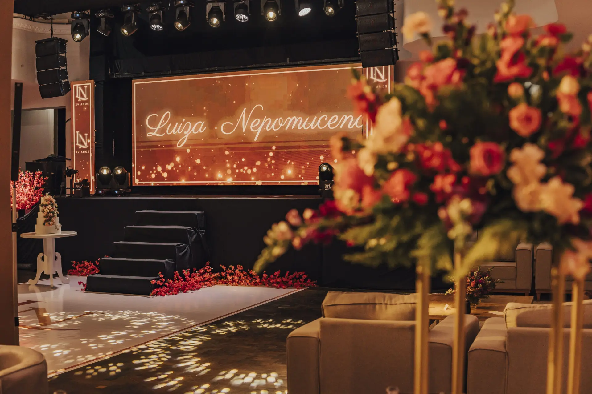 Palco de festa de 15 anos com painel de LED personalizado e flores vermelhas